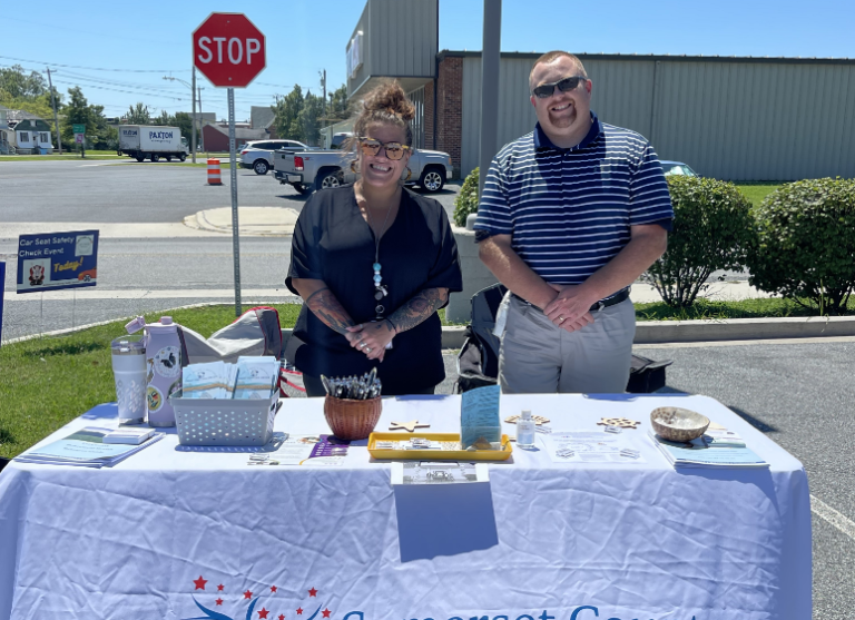 Photo of SCLMB team members smiling and standing behind an event table